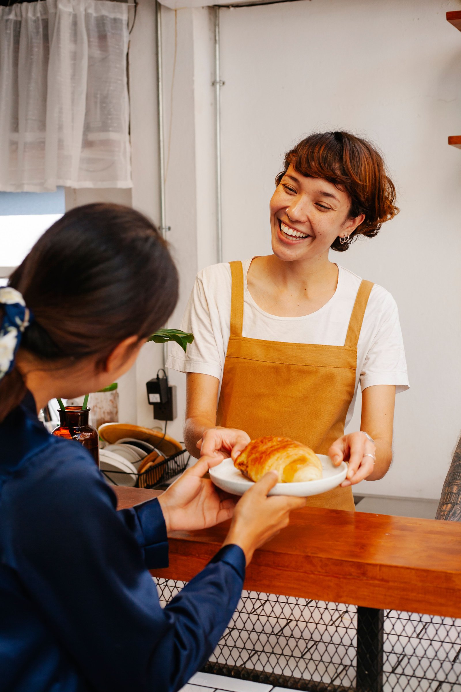 A barista greeting a regular customer with a smile