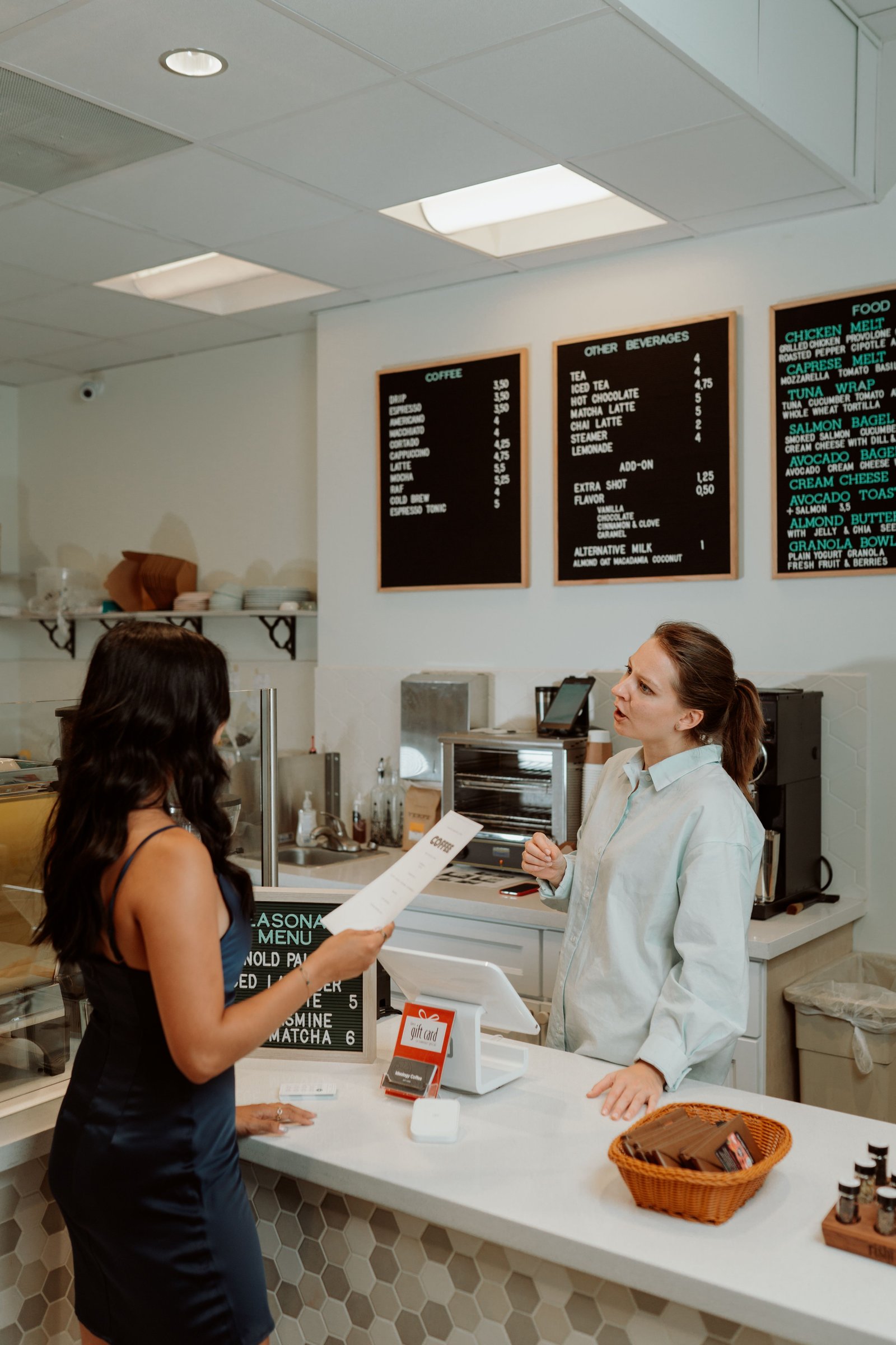 A woman pushes open the door of a café for the first time