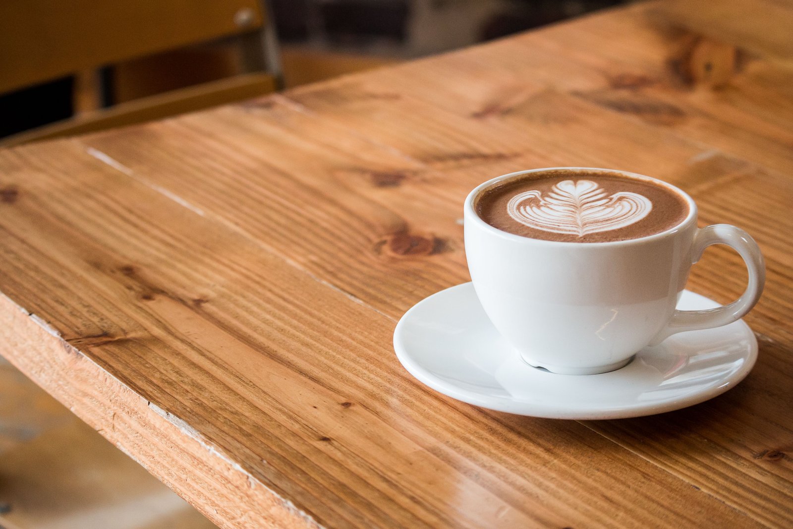 A café table with a coffee and a phone in warm window light
